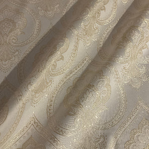 textured fabric with intricate paisley pattern in beige tones.