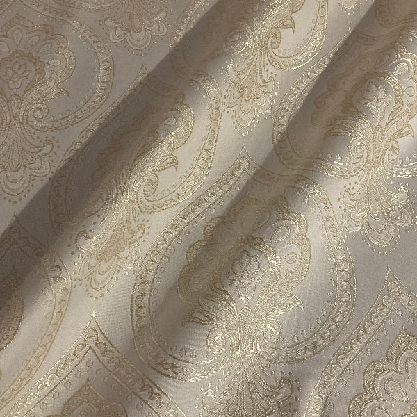 textured fabric with intricate paisley pattern in beige tones.